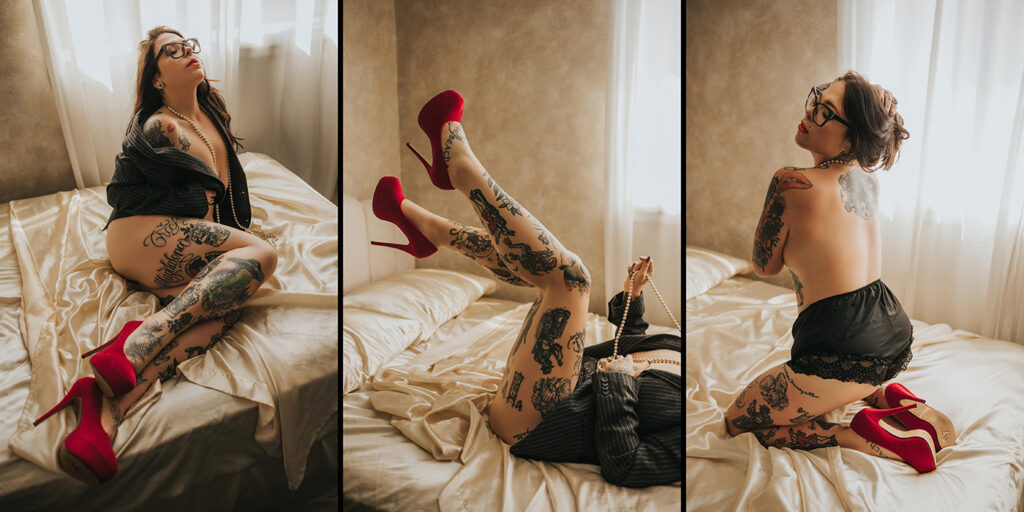 during her boudoir photoshoot, woman poses on a bed in red heels, pearls and black blazer